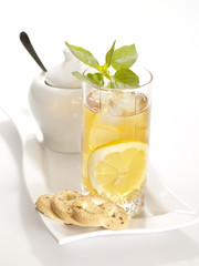 Cold black tea with lemon ice and water drops on the glass surfa