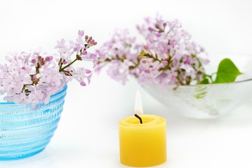 Candles, flowers for aromatherapy treatment on white background