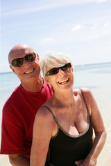 Fototapeta premium Portrait d'un couple de seniors souriants au bord de la plage