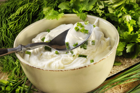 Eine Schale Quark mit Kr&auml;utern im Hintergrund