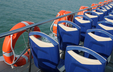 Fototapeta na wymiar Life belts and chairs back on a touristic boat
