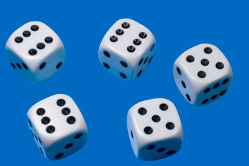 Five white dices against a blue background