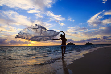 Fototapeta na wymiar woman in a bikini walking on the beach at sunrise