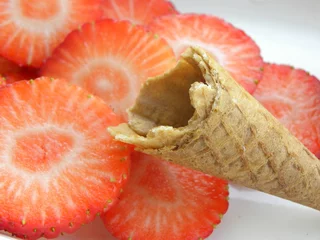 Crédence de cuisine en plexiglas Tranches de fruits cornet de crème glacée devant des tranches de fraise