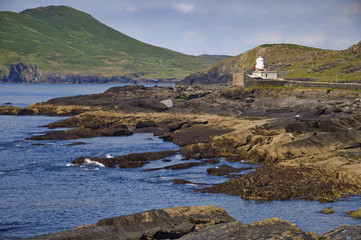 remote coastal old lighhouse seascape with mountain landscape