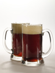 two  ale mug with drink on the table