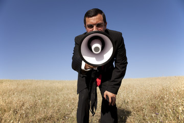 Businessman shouting at the megaphone to you