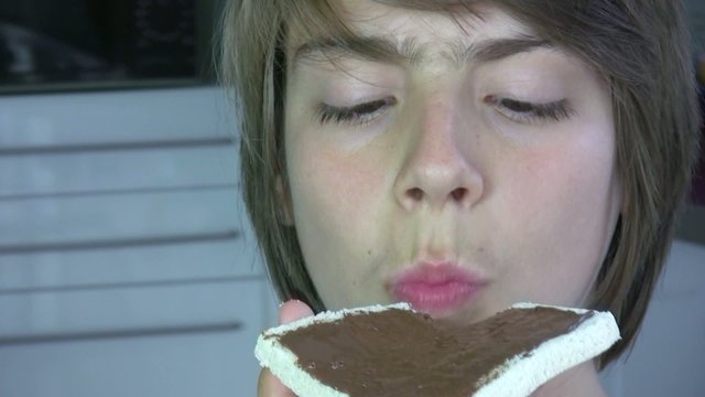 adolescent mangeant une tartine de chocolat