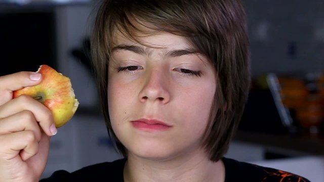adolescent croquant une pomme