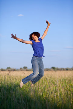 The  woman jumps in a grass