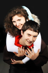 Youths fellow with a girl hug on a black background