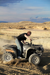 Fototapeta na wymiar teen riding quad ATV in the hills