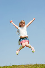 Little girl jumping against beautiful sky