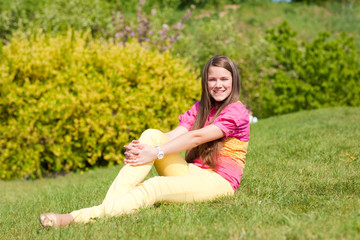 Fototapeta premium Pretty smiling girl relaxing on green meadow. Soft focus. Focus