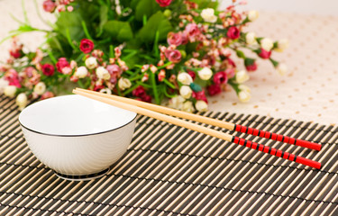 Chopsticks and bowl on the bamboo mat