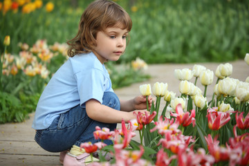 little girl sits at bed with tulips