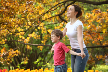Mother with son to keep for hands in garden in spring