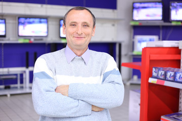 elderly man with  crossed hands in radio engineering shop