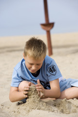 little boy playing with sand