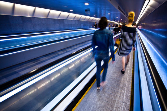 Blue moving escalator with people