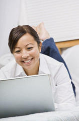 Attractive Asian Woman Lying Down with Laptop