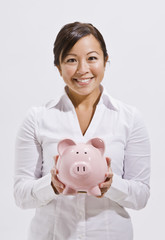 Fototapeta na wymiar Beautiful Asian Woman Holding Piggy Bank