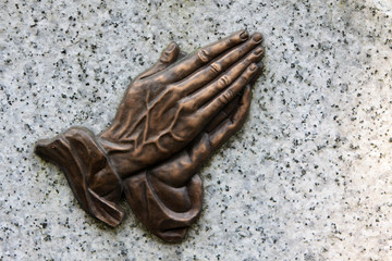 Betende Hände auf einem Grabstein