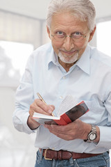 Aged man makes notes