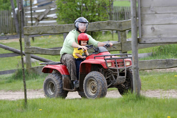 Dad with son riding a quad