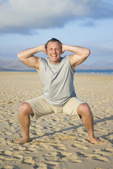 man performing exercises on beach.
