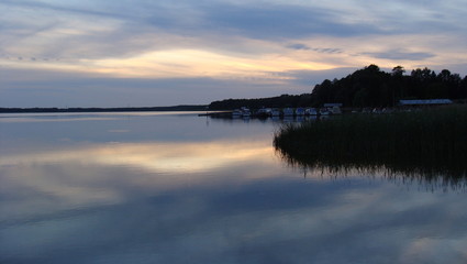 Blaue Stunde am See -  Wolken spiegeln sich auf der glatten Wasseroberfläche - grau blau rosa Farben