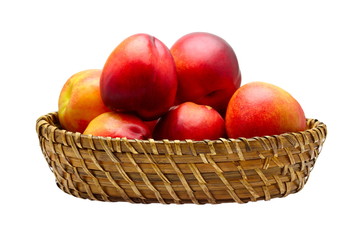 Basket full of fresh peaches isolated on white background