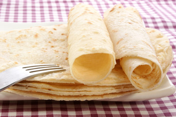 aufgerollter Palatschinken vor der Zubereitung auf einem Teller