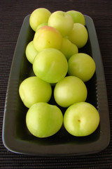 Green plums on black background