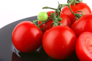 fresh uncooked tomato close up on black