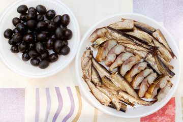 Black olives and plate of smoked sprat and sliced mackerel