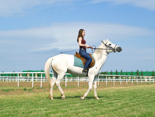 girl astride a horse on a hippodrome