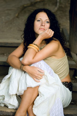 Fototapeta premium attractive woman sitting on wooden stairs