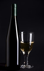 Wine bottle and glass on black background