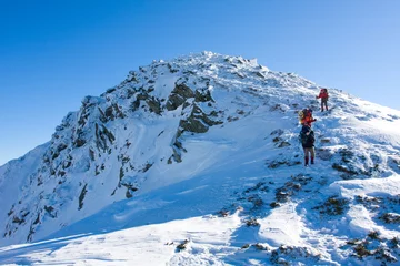 Fotobehang Hikers are in winter in mountains © Maygutyak