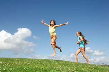 Deux jeunes filles jouant sur une colline verte