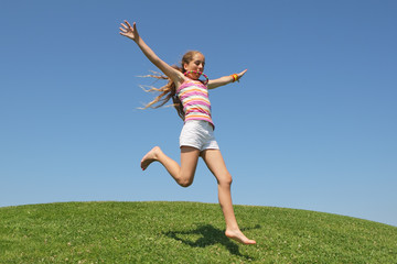 Enfant courant sur un colline verte