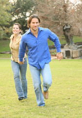 Happy Young Couple Running In Park