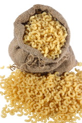 macaronis in a sack and spilled on a white background