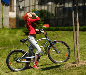 girl on bicycle drink water