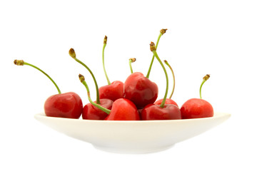Group of ripe cherries on a white plate