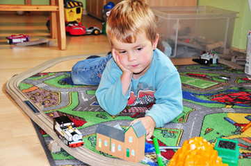 Kind spielt mit seiner Eisenbahn