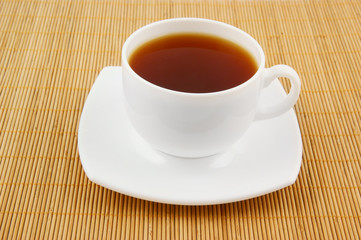 White cup of tea on wooden background