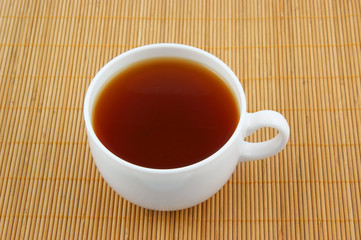 White cup of tea on wooden background