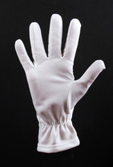 Open left hand in white glove on black background.